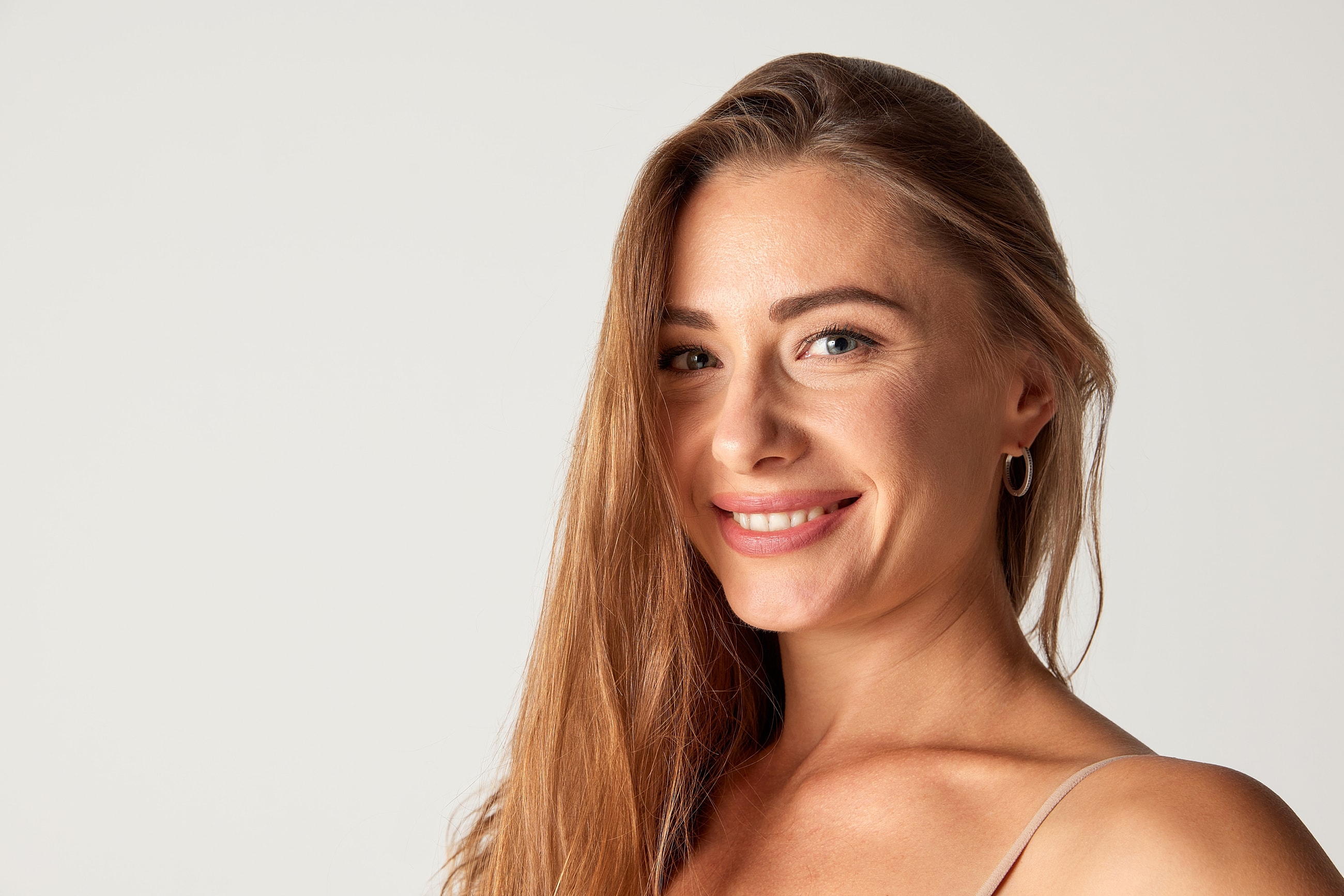Smiling woman with long hair against white background
