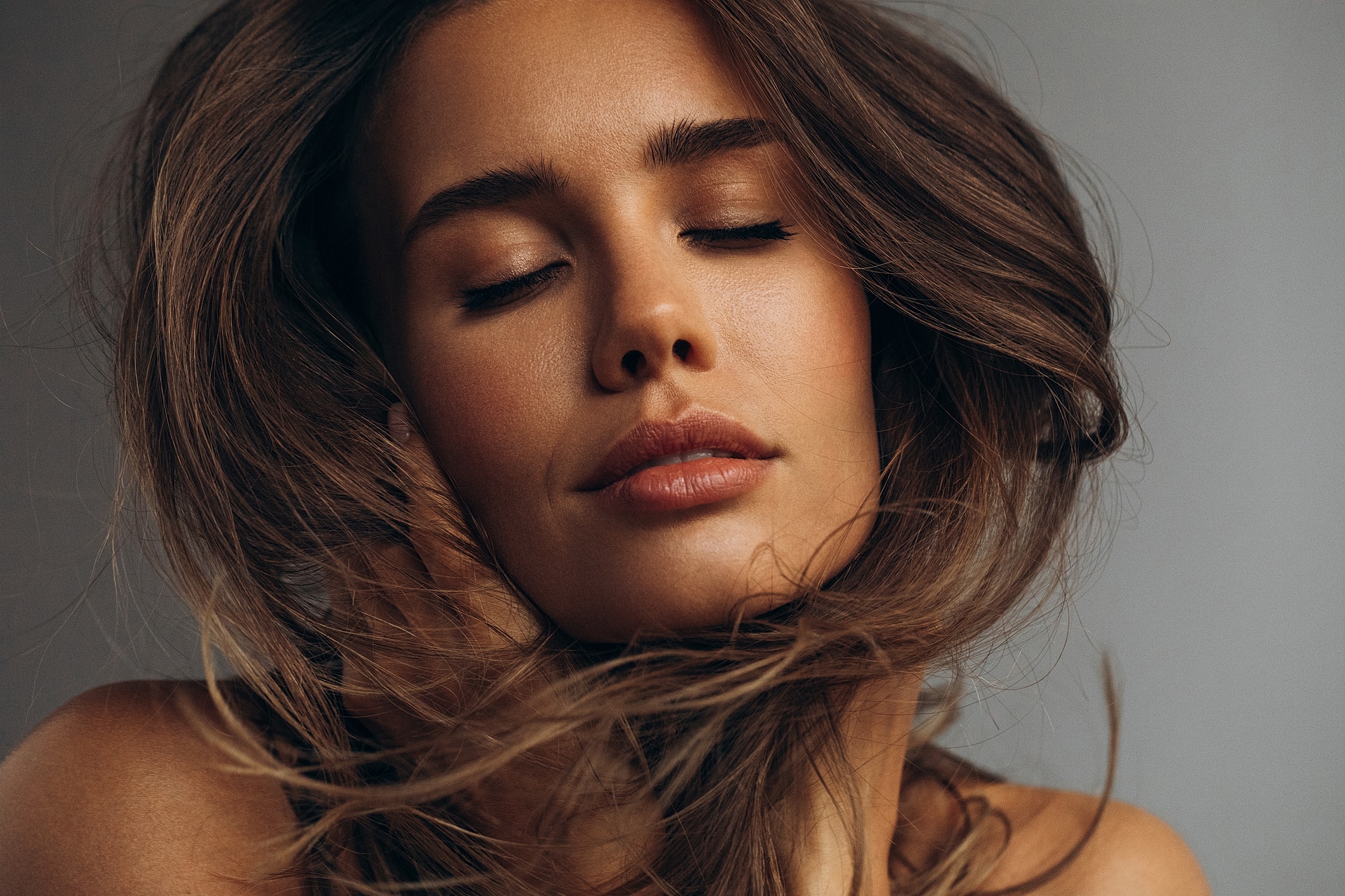 Woman with flowing hair and closed eyes.