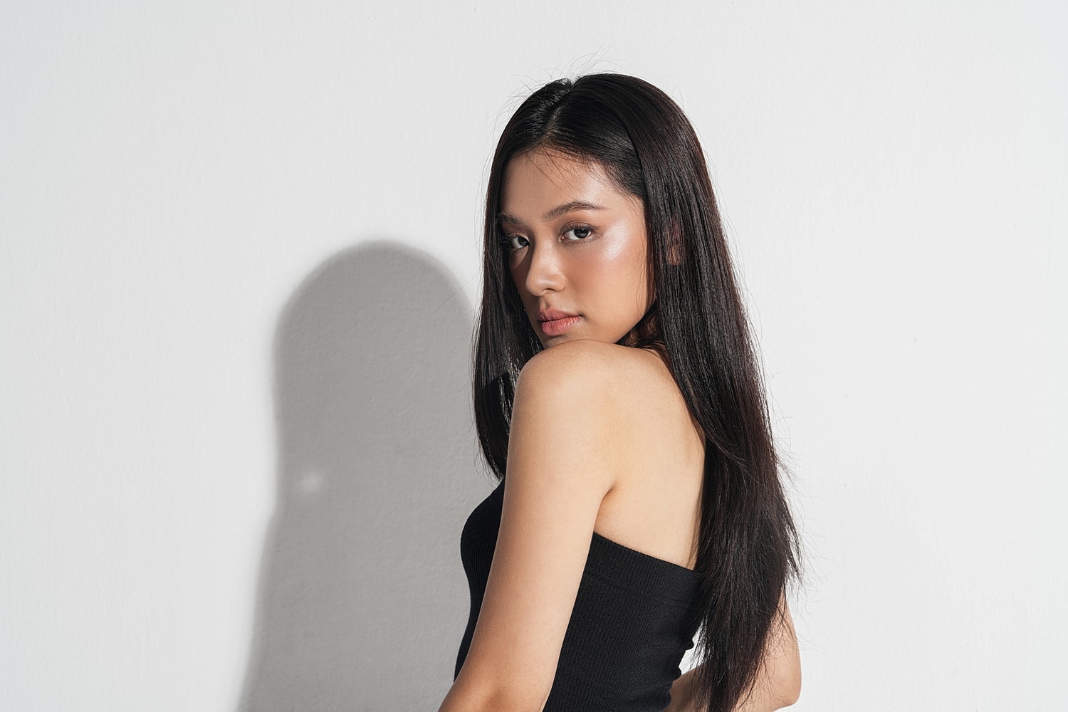 Profile of a young woman against white background.